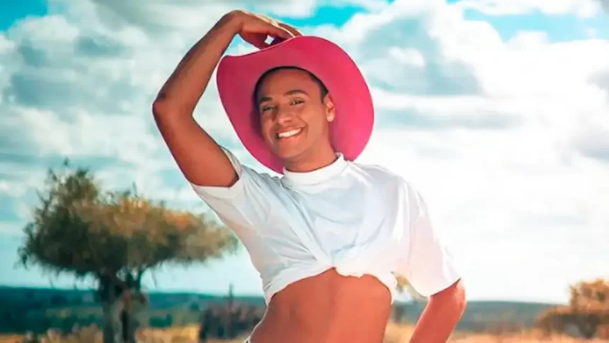 Ney Lima sorrindo, segurando um chapéu de cowboy rosa com a mão direita durante ensaio fotográfico para as redes sociais