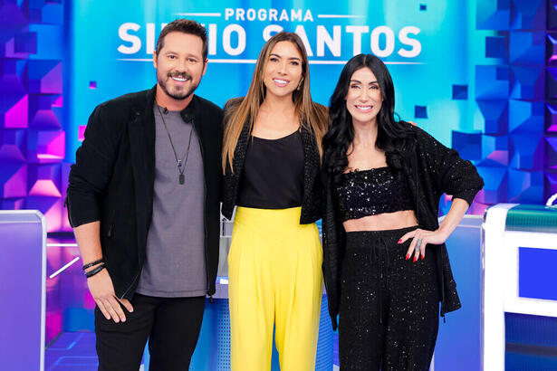 Donny De Nuccio, Patricia Abravanel e Michelle Barros abraçados, em frente a roleta do Jogo das 3 P