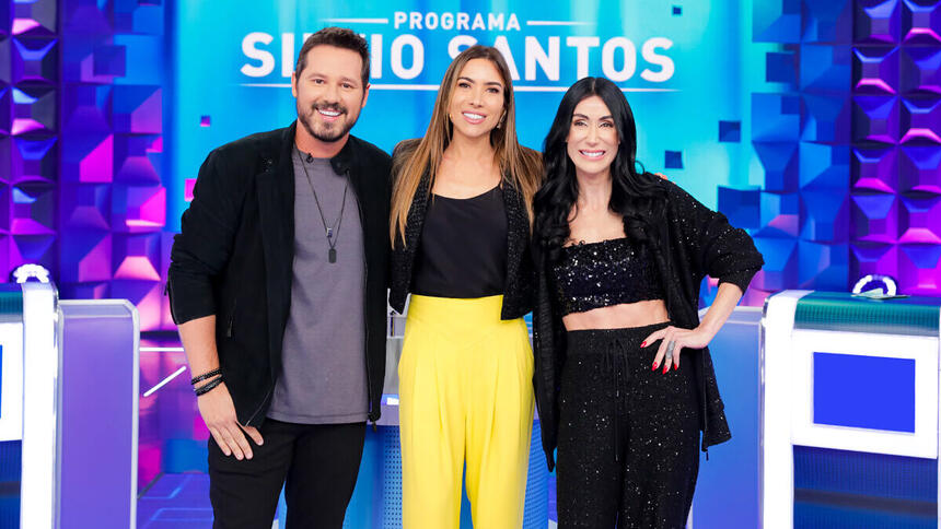 Donny De Nuccio, Patricia Abravanel e Michelle Barros abraçados, em frente a roleta do Jogo das 3 P