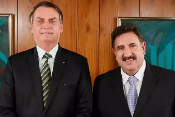 Ratinho e Bolsonaro de palitó preto, gravata e camisa branca sorrindo durante entrevista em 2018