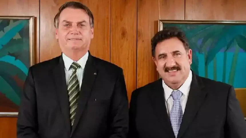 Ratinho e Bolsonaro de palitó preto, gravata e camisa branca sorrindo durante entrevista em 2018