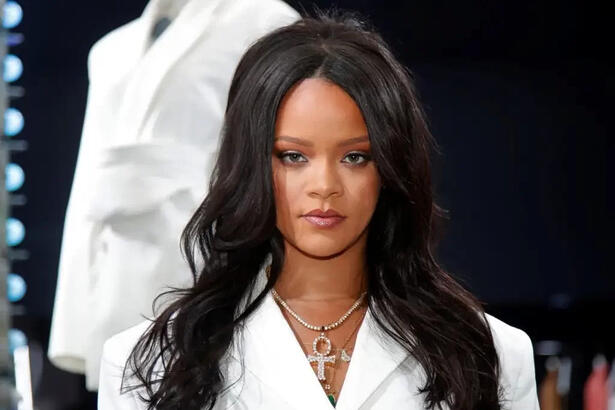 Rihanna vestida de branco e com cabelo grande