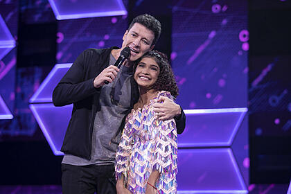 Rodrigo Faro abraçando a candidata Beatriz Moraes nos estúdios do Canta Comigo Teen 3