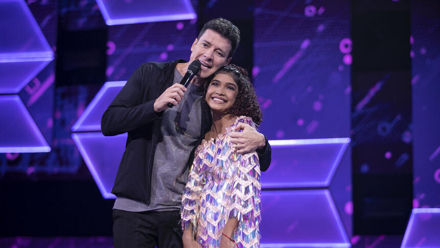 Rodrigo Faro abraçando a candidata Beatriz Moraes nos estúdios do Canta Comigo Teen 3