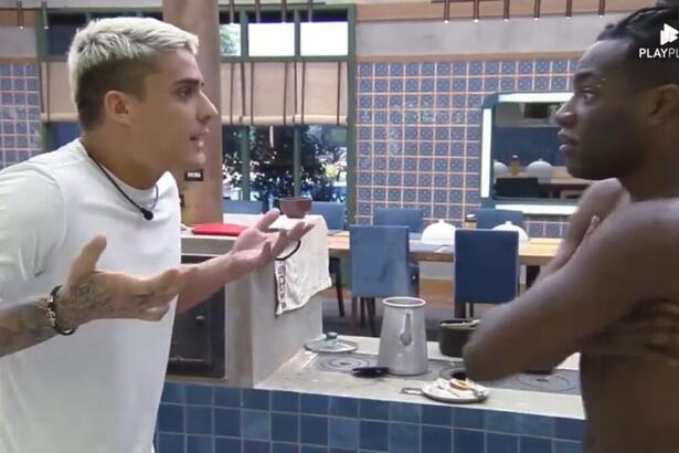 Tiago de frente para Pelé que está com os braços cruzados.