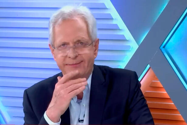 Augusto Nunes com o dedo no queixo, no estúdio da Jovem Pan News