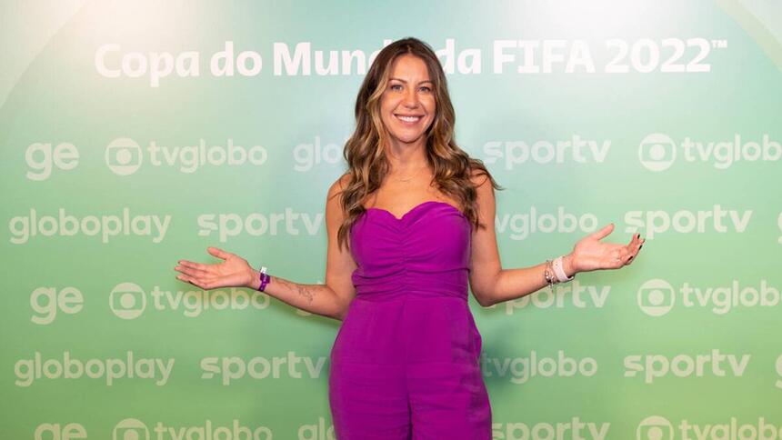 Bárbara Coelho em frente ao banner de divulgação da Copa do Mundo 2022 na Globo