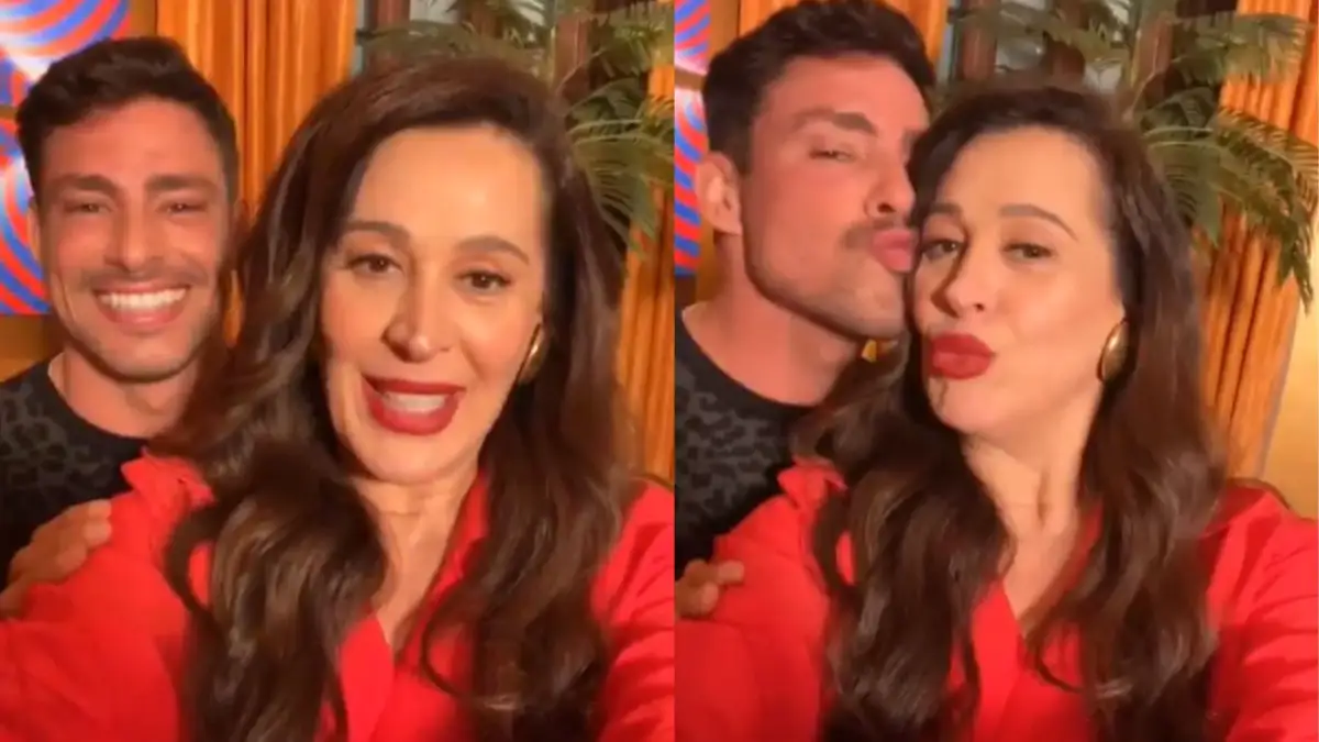 Claudia Raia de camisa vermelha ao lado de Cauã Reymond durante gravação