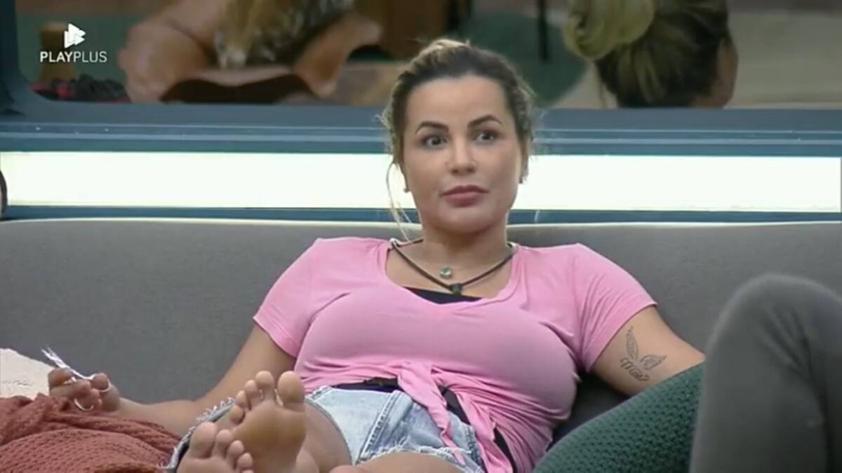 Deolane sentada no sofá da sala de A Fazenda 14