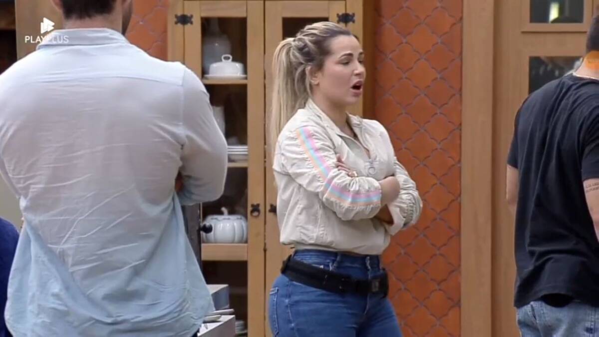Deolane na cozinha com os braços cruzados.