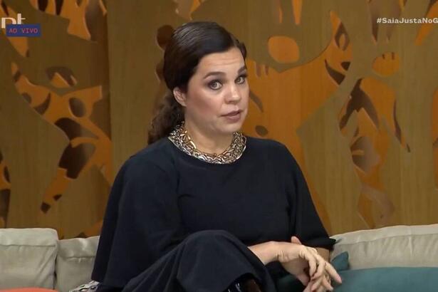 Isabel Teixeira sentada no sofá do Saia Justa, em trecho da entrevista