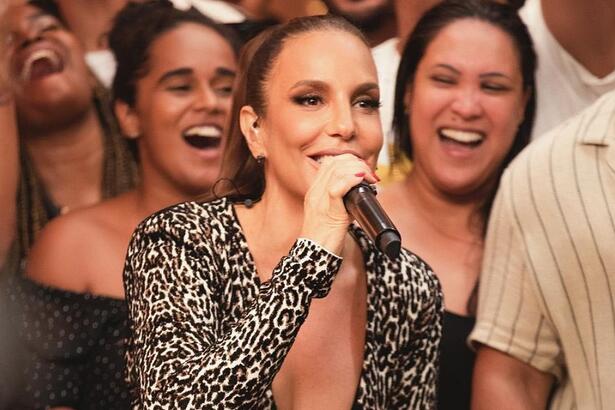 Ivete Sangalo com macacão decotado, animal print, cantando durante gravação do Macaco Sessions