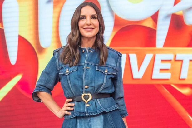 Ivete Sangalo com look jeans azul, sorrindo, com a mão na cintura, cabelo solto durante gravação do Pipoca da Ivete, da TV Globo