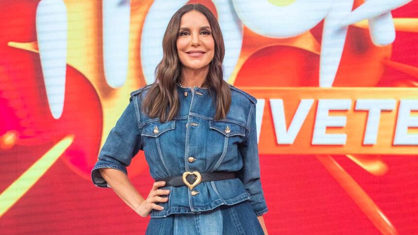 Ivete Sangalo com look jeans azul, sorrindo, com a mão na cintura, cabelo solto durante gravação do Pipoca da Ivete, da TV Globo