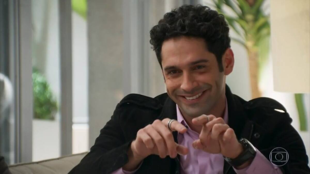 João Baldesserini fazendo coração com a mão, sorrindo, durante gravaçao de novela da tv globo