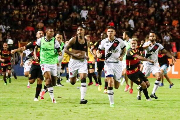 Jogadores de Vasco e Sport Recife corendo em campo, em meio a invasão de torcida na Ilha do Retiro