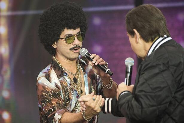 Marco Luque apertando a mão de Faustão durante gravação de programa