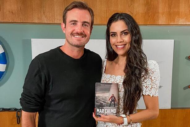 Max Fercondini sorrindo, de bigode, camisa preta ao lado de Daniela Albuquerque