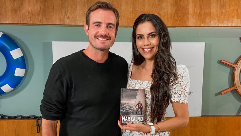 Max Fercondini sorrindo, de bigode, camisa preta ao lado de Daniela Albuquerque