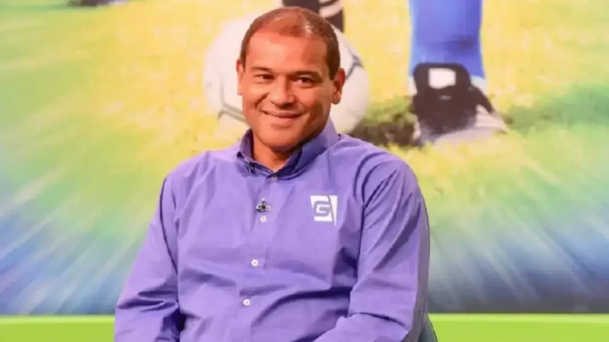 Muller de camisa social azul, sentado, sorrindo durante entrevista