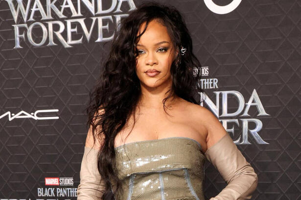 Rihanna com vestido na frente de uma imagem escrito Pantera Negra