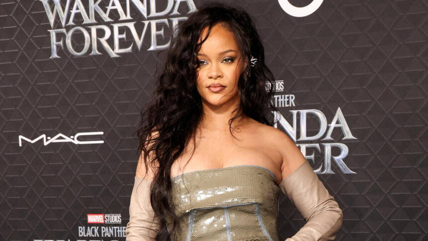 Rihanna com vestido na frente de uma imagem escrito Pantera Negra