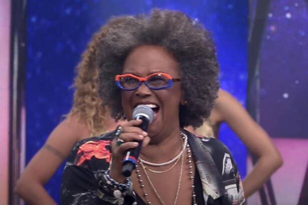 Sandra de Sá com o microfone na mão direita durante performance no Programa do Faustão