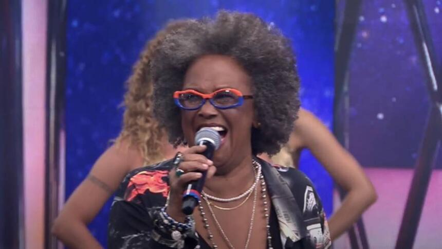 Sandra de Sá com o microfone na mão direita durante performance no Programa do Faustão