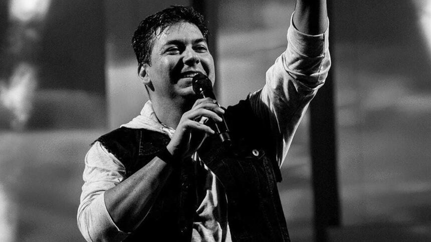 Sérgio Missão em trecho de um show pela banda, em uma foto em preto e branco