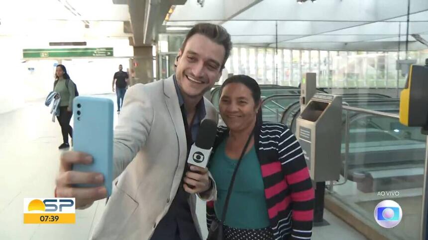 Tiago Scheuer tirando um selfie ao vivo ao lado de uma senhora