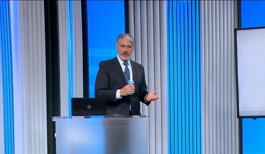 Bonner segurando a latinha de água nos estúdios da apuração da TV Globo