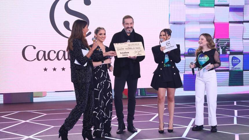 Alê Costa e sua filha segurando o cheque, ao lado de Maísa Silva, Isabella Fiorentino, Lexa, Sophia Valverde e Igor Jansen no palco do Teleton