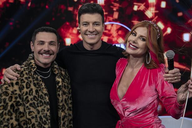 Alex, Rodrigo Faro e Deborah abraçados e sorridentes durante gravação do Hora do Faro