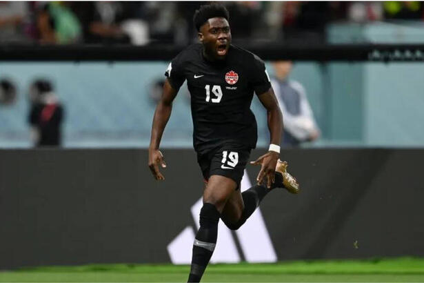 Alphonso Davies sozinho no gramado comemorando um gol com a camisa do Canadá