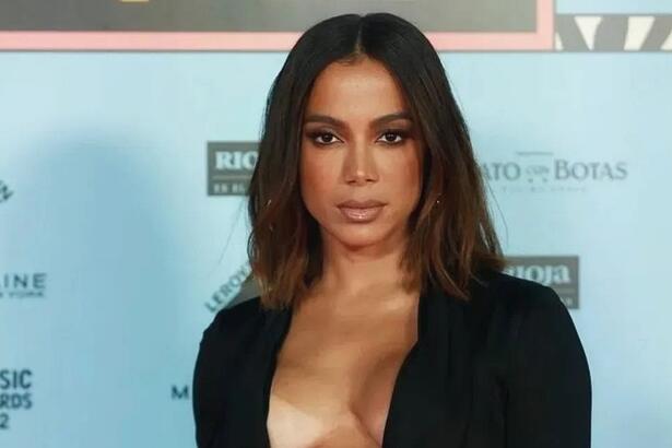 Anitta de vestido preto com semblante sério durante red carpet de premiação internacional