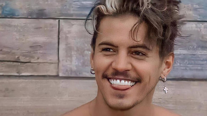 Biel com um sorriso aberto, brincos nas orelhas