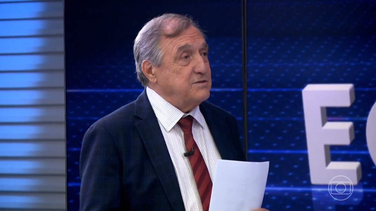 Carlos Alberto Sardenberg com uma folha não, em frente ao telão do Jornal da Globo
