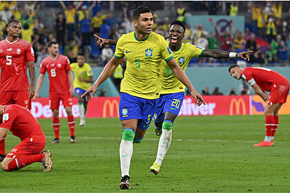 Casemiro e Vinícius Jr de braços abertos e comemorando gol com a camisa do Brasil, na partida contra Suíça na Copa do Mundo