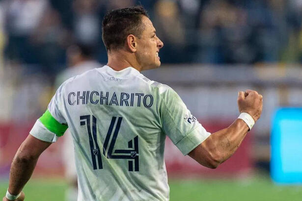 Chicharito, em campo com a camisa do México, porém de costa para a câmera, mostarndo apenas o número 14 na camisa com o seu nome