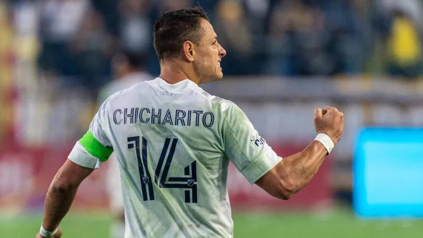 Chicharito, em campo com a camisa do México, porém de costa para a câmera, mostarndo apenas o número 14 na camisa com o seu nome