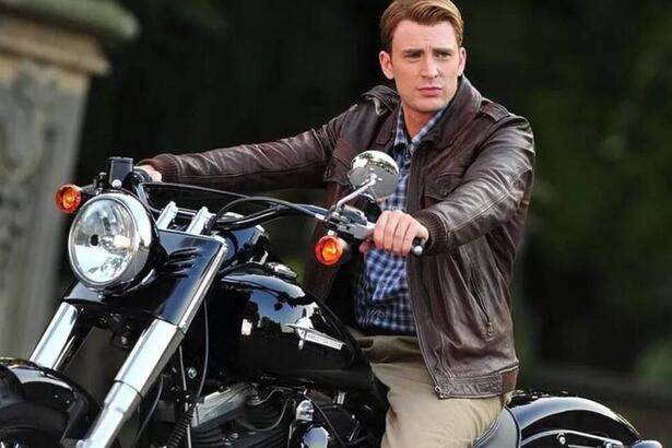 Chris Evans em foto posada em cima de uma moto, utilizando uma jaqueta de couro