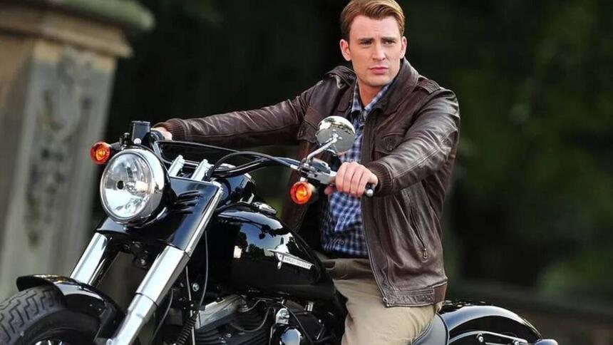 Chris Evans em foto posada em cima de uma moto, utilizando uma jaqueta de couro