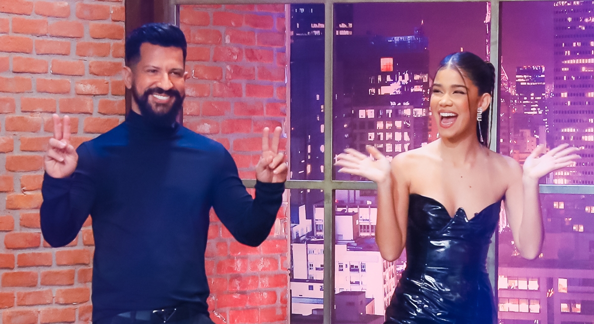 Dennis DJ, fazendo sinal de V de vitória ao lado de sua filha. Eles entram no palco do The Noite sorridentes