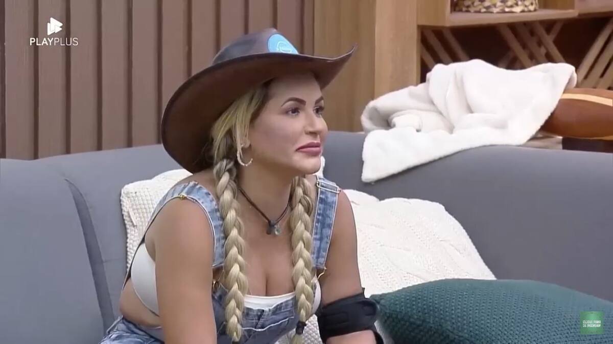 Deolane sentada na sala de A Fazenda olhando para frente.