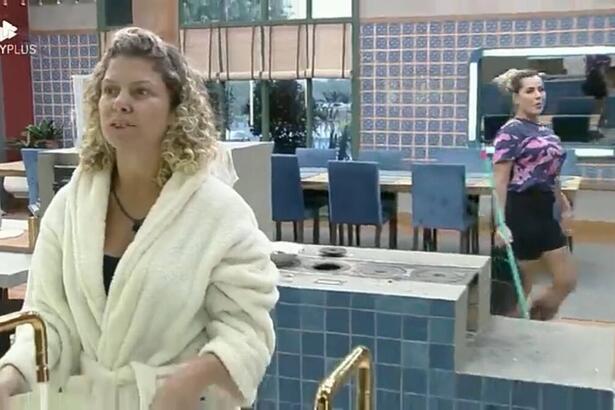 Bárbara de frente para o espelho da cozinha olhando para Deolane