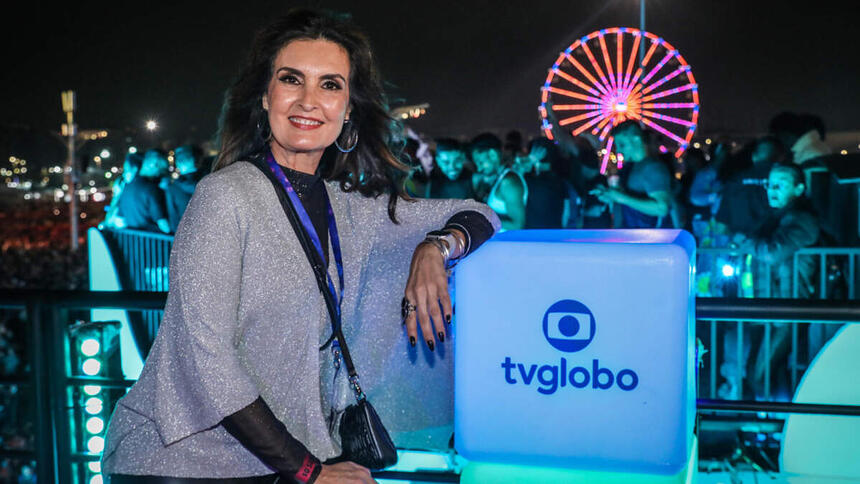 Fátima Bernardes em foto posada, do lado do totén da Globo na cobertura do Rock in Rio