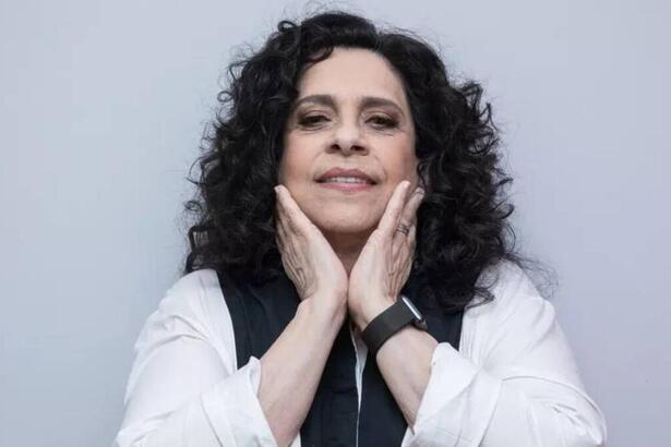 Gal Costa com as mãos próximas ao pescoço, em foto posada