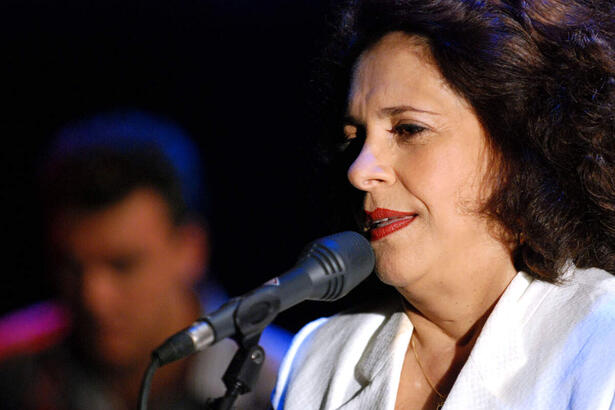 Gal Costa de camisa branca, batom vermelho em frente ao microfone durante gravação do Ensaio, de 2008