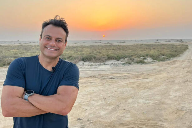 Eric Faria posando em um deserto do Catar, em trecho do Globo Repórter