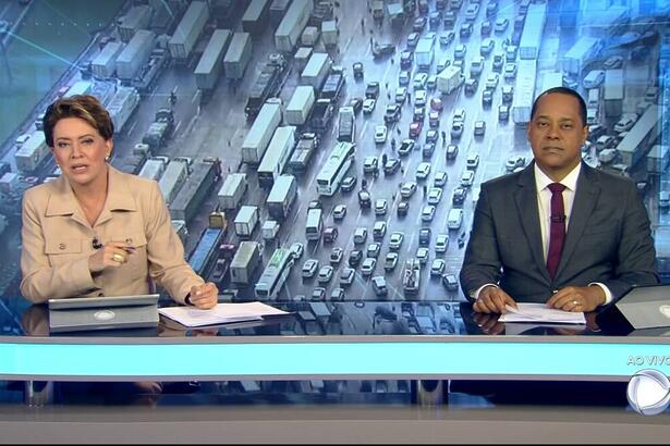 Christina Lemos e Luiz Fara Monteiro sentados na bancada do Jornal da Record